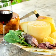 Ein Glas Rotwein, passend zu Käse und Salami. Der Wein könnte aus der Nebbiolo Traube stammen.