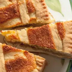 Ein Stück Pastiera Napoletana, ein traditioneller italienischer Kuchen, mit Gittermuster. Das Rezept ist einfach und das Ergebnis köstlich.