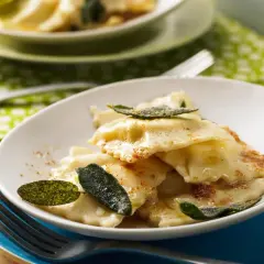 Ravioli ricotta mit Salbeibutter und zerstoßenem Pfeffer, garniert mit frischen Salbeiblättern. Ein Genuss für Feinschmecker.