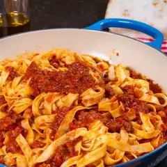 Herzhaftes Tagliatelle Bolognese, ein authentisches spaghetti bolognese rezept original, serviert in einer blauen Pfanne.