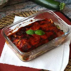 Herzhaftes Zucchini Piccata im Glasauflauf, mit Tomatensauce und Basilikum garniert.