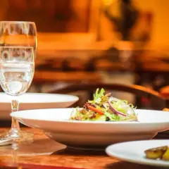 Ein gedeckter Tisch mit Speisen und Gläsern, bereit für ein köstliches Essen mit Wein zum Essen.