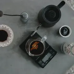Kaffeetrinker bereiten einen perfekten pour over zu: Kaffeemühle, Wasserkocher, Waage und Filter sind bereit.
