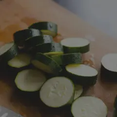 Frisch geschnittene Zucchini-Scheiben auf einem Holzbrett. Die Zucchini haltbarkeit ist gut, wenn sie richtig gelagert wird.