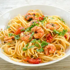 Ein Teller Spaghetti Frutti di Mare Rezept Original mit Garnelen, Tomaten und Petersilie.