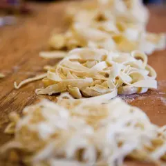 Frische Bandnudeln liegen auf einem Holztisch, bereit für ein leckeres Bandnudeln Rezept.