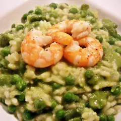 Cremiges Risotto mit Erbsen und drei saftigen Garnelen, ein Genuss für Augen und Gaumen.