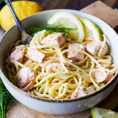 Eine Schüssel Pasta mit Lachs, garniert mit Dill und Zitronenscheiben. Ein köstliches Pasta Salmone Gericht.