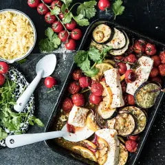 Ofenfrisches Gericht mit Aubergine, Tomaten und Feta. Dazu Orzo-Nudeln und frische Kräuter.