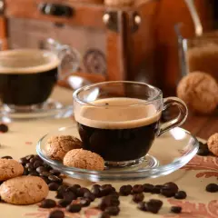 Zwei Tassen italienische Kaffeesorten mit Amarettini und Kaffeebohnen.