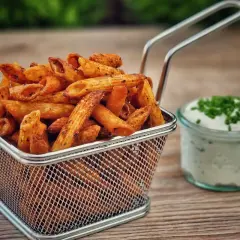 Knusprige Pasta Chips in einem Metallkorb, daneben ein Dip mit Schnittlauch. Ein leckerer Snack für zwischendurch.