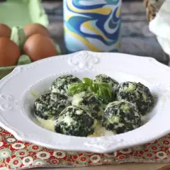 Malfatti rezept: Grüne, käsige Klößchen mit Spinat und Basilikum auf einem Teller, daneben Eier im Karton.