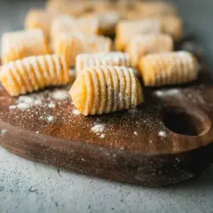 Frisch zubereitete Gnocchi liegen auf einem Holzbrett. Diese kleinen Teigklößchen sind ein Klassiker der italienischen Küche.