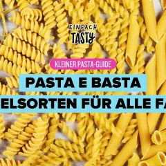 Bunte Nudelsorten wie Penne, Fusilli und Spaghetti liegen nebeneinander. Ein kleiner Pasta-Guide erklärt, wie lange Penne kochen.