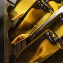 Flaschen mit Hefeablagerungen im Rüttelpult, ein Zeichen für die traditionelle Methode Champenoise.