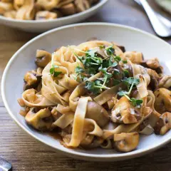 Herzhafte Pasta mit Pilzen, ein klassisches italienisches Gericht, garniert mit frischen Sprossen.
