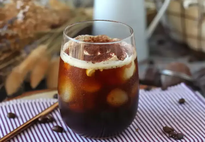 Erfrischender Eiskaffee mit Sahne und Kakaopulver, perfekt für heiße Tage. Tolle Inspiration für Kaffee Rezepte.