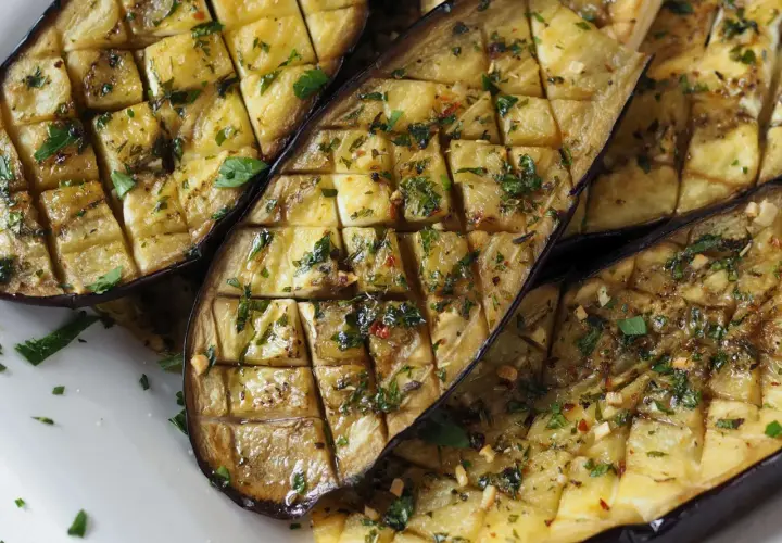 Ganze Aubergine im Ofen, in Scheiben geschnitten und mit Kräutern und Gewürzen verfeinert, bereit zum Genuss.