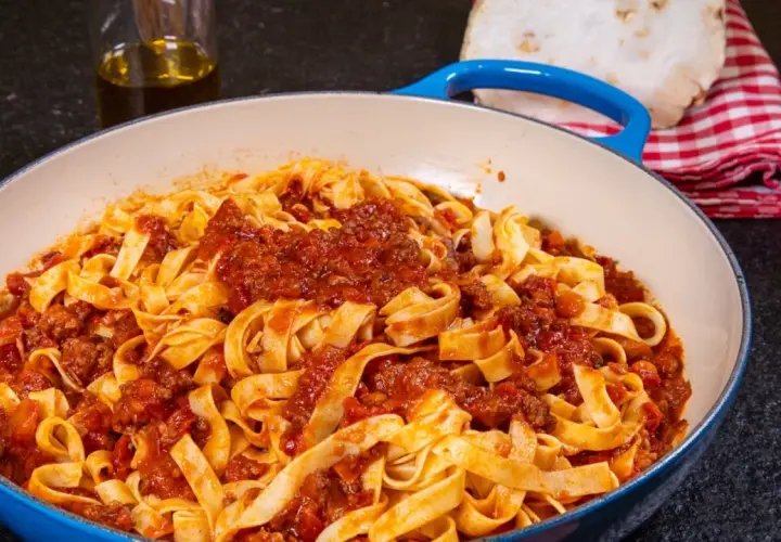 Herzhaftes Tagliatelle Bolognese, ein authentisches spaghetti bolognese rezept original, serviert in einer blauen Pfanne.