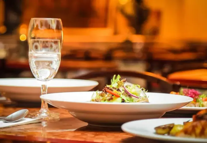 Ein gedeckter Tisch mit Speisen und Gläsern, bereit für ein köstliches Essen mit Wein zum Essen.