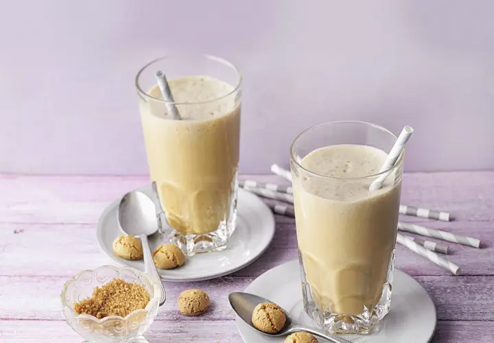 Zwei cremige Espresso Frappés mit Keksen und braunem Zucker.
