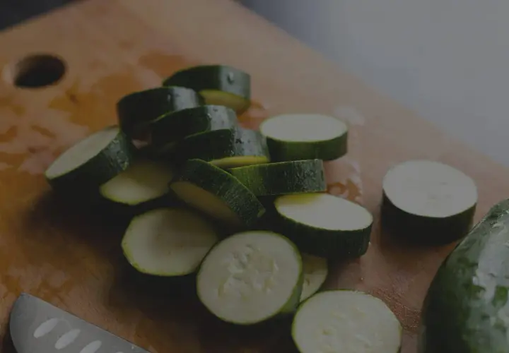 Frisch geschnittene Zucchini-Scheiben auf einem Holzbrett. Die Zucchini haltbarkeit ist gut, wenn sie richtig gelagert wird.