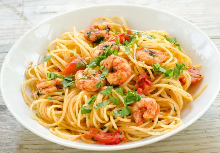 Ein Teller Spaghetti Frutti di Mare Rezept Original mit Garnelen, Tomaten und Petersilie.