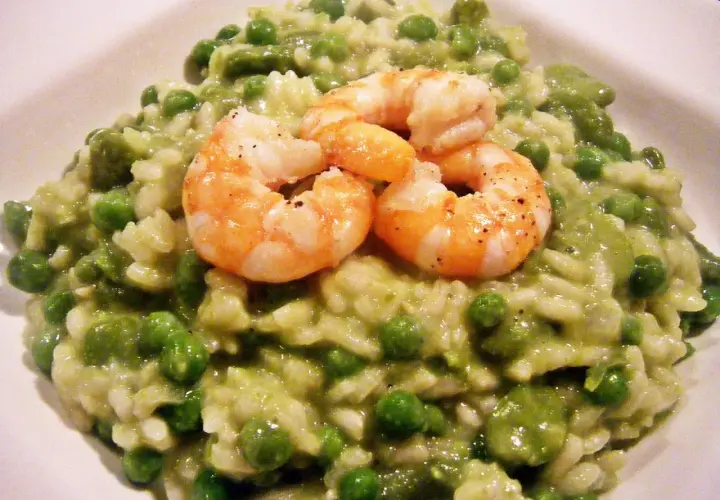 Cremiges Risotto mit Erbsen und drei saftigen Garnelen, ein Genuss für Augen und Gaumen.