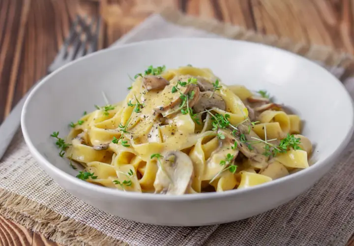 Cremige Tagliatelle mit Pilzen, garniert mit frischen Kräutern und schwarzem Pfeffer. Ein köstliches Gericht, das Lust auf mehr macht.