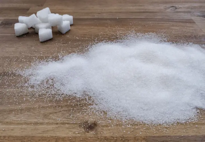 Zuckerwürfel und ein Haufen feiner Kristalle, die an eine süße Versuchung erinnern, fast wie eine Prise Zucker für den Rotwein.