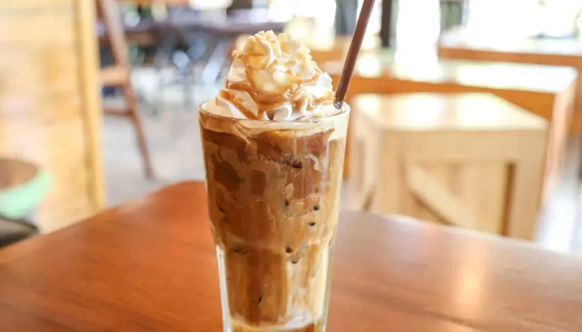 Ein cremiger Eiskaffee mit Sahne und Karamellsoße, perfekt für ein Eiskaffee Rezept.