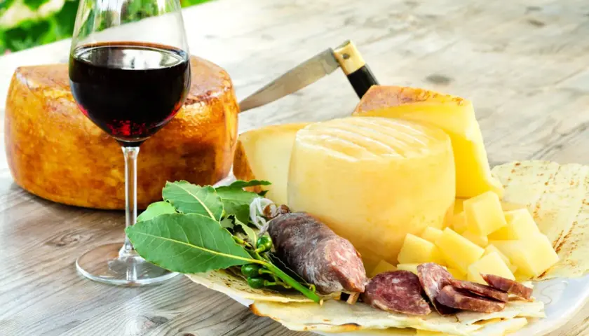 Ein Glas Rotwein, passend zu Käse und Salami. Der Wein könnte aus der Nebbiolo Traube stammen.