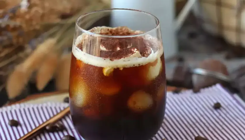 Erfrischender Eiskaffee mit Sahne und Kakaopulver, perfekt für heiße Tage. Tolle Inspiration für Kaffee Rezepte.