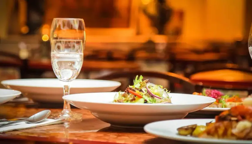Ein gedeckter Tisch mit Speisen und Gläsern, bereit für ein köstliches Essen mit Wein zum Essen.