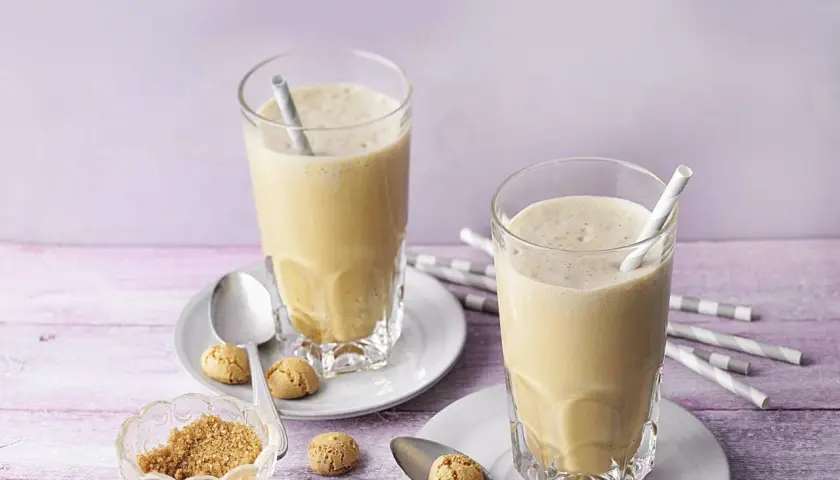 Zwei cremige Espresso Frappés mit Keksen und braunem Zucker.