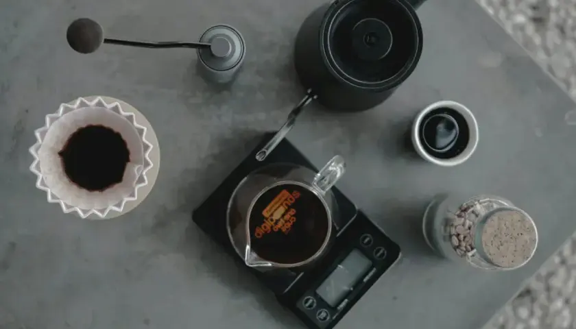 Kaffeetrinker bereiten einen perfekten pour over zu: Kaffeemühle, Wasserkocher, Waage und Filter sind bereit.