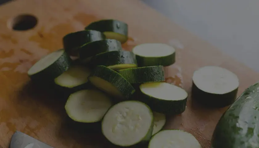 Frisch geschnittene Zucchini-Scheiben auf einem Holzbrett. Die Zucchini haltbarkeit ist gut, wenn sie richtig gelagert wird.