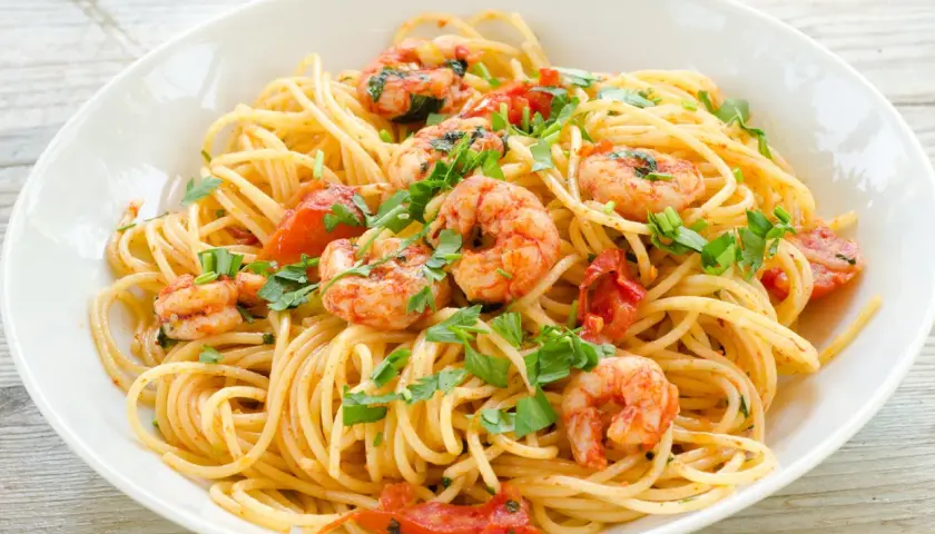 Ein Teller Spaghetti Frutti di Mare Rezept Original mit Garnelen, Tomaten und Petersilie.