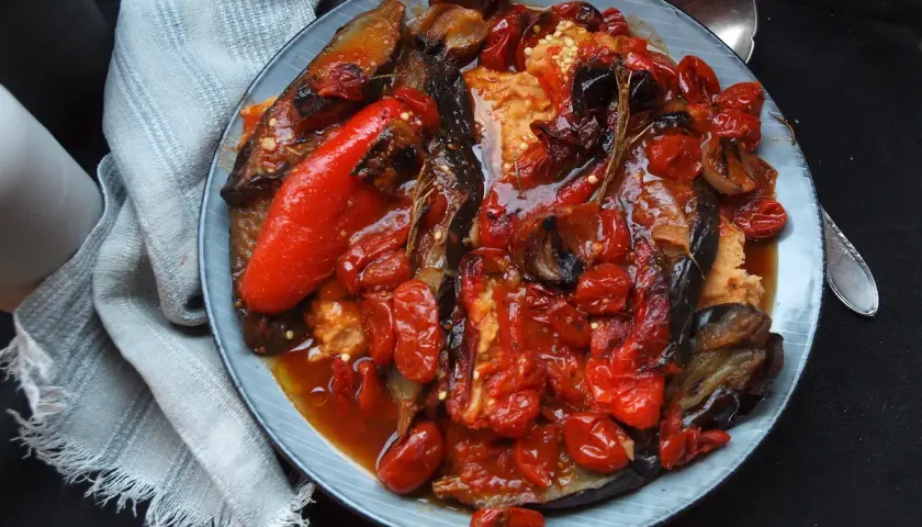 Herzhaftes aubergine paprika rezept: Gegrillte Auberginen und Paprika mit Tomaten und Zwiebeln in einer würzigen Sauce.