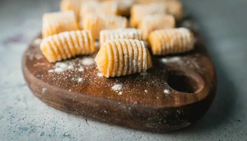 Frisch zubereitete Gnocchi liegen auf einem Holzbrett. Diese kleinen Teigklößchen sind ein Klassiker der italienischen Küche.