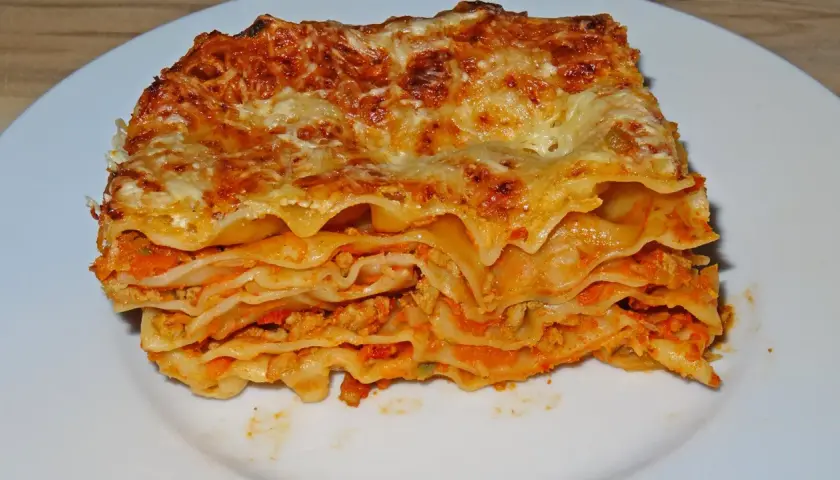 Ein Stück Lasagne mit Hackfleisch, geschichtet mit Nudelplatten und Tomatensauce, überbacken mit Käse.
