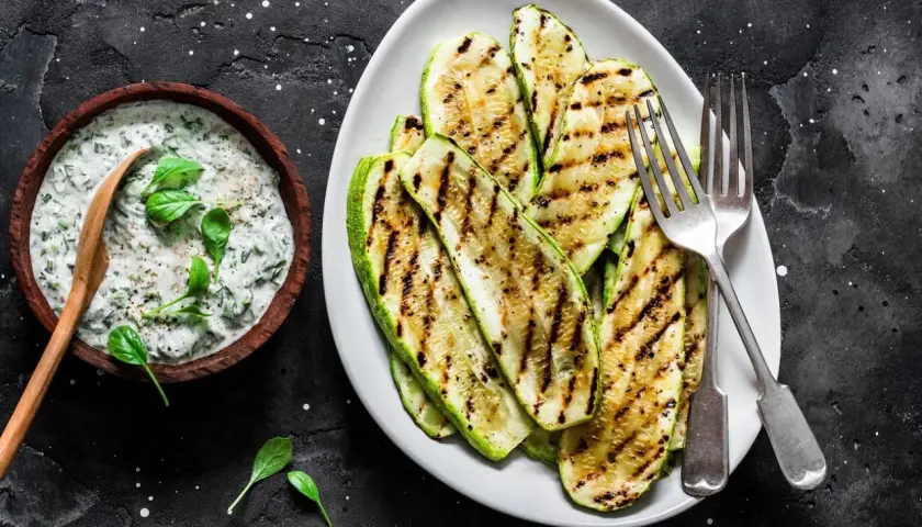 Gegrillte Zucchinischeiben mit Kräuterquark. Perfekt zum **Zucchini zubereiten** für einen leichten Genuss.