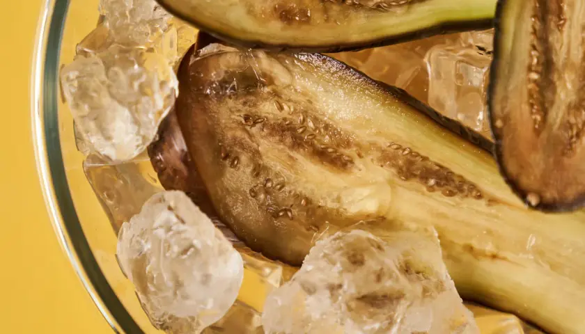 Gekühlte Auberginenscheiben in Eiswürfeln. Perfekt für das Aubergine einfrieren, um Frische zu bewahren.