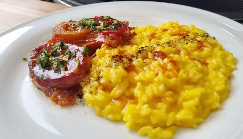 Ossobuco, ein geschmortes Kalbshaxengericht, serviert mit cremigem Safranrisotto.