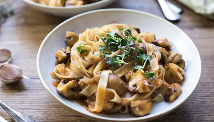 Herzhafte Pasta mit Pilzen, ein klassisches italienisches Gericht, garniert mit frischen Sprossen.