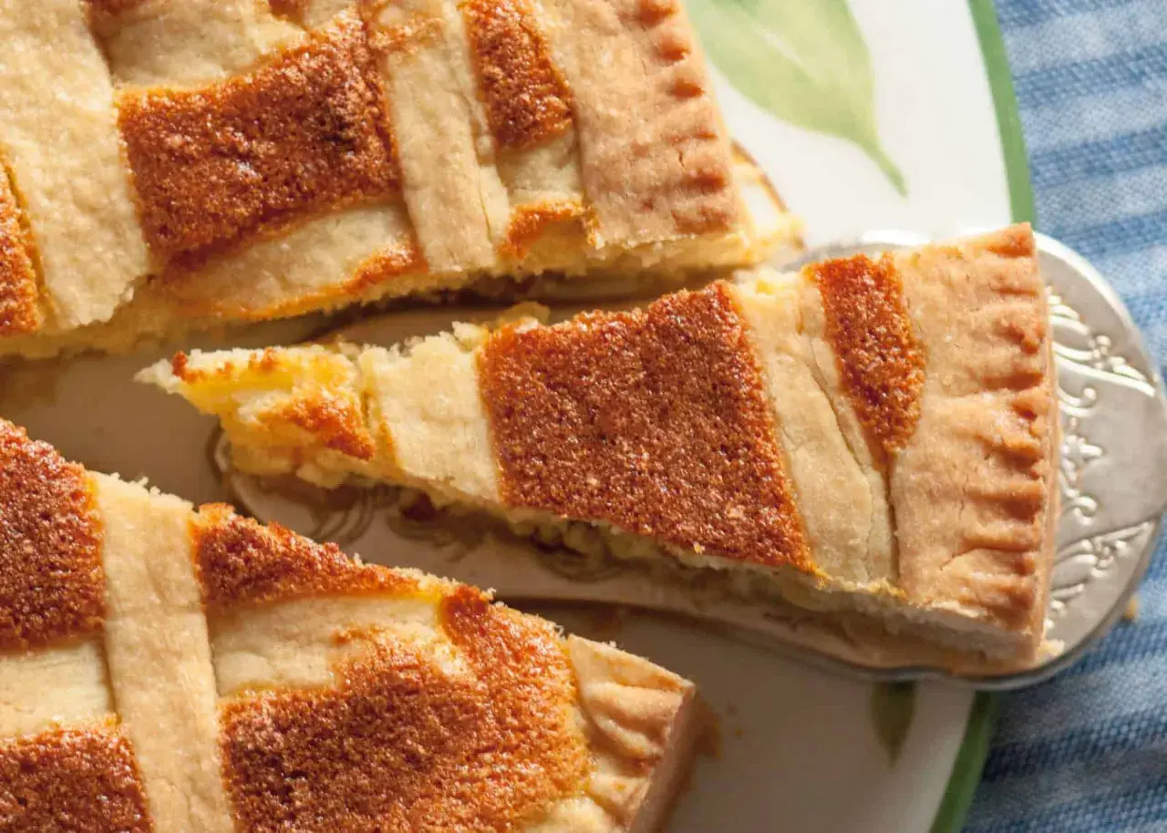 Ein Stück Pastiera Napoletana, ein traditioneller italienischer Kuchen, mit Gittermuster. Das Rezept ist einfach und das Ergebnis köstlich.