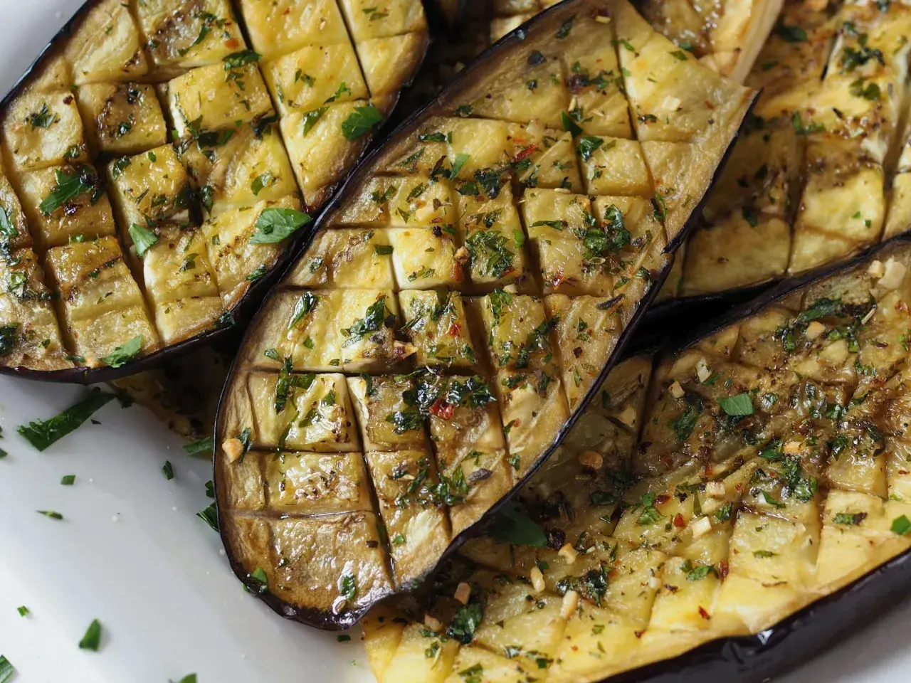 Ganze Aubergine im Ofen, in Scheiben geschnitten und mit Kräutern und Gewürzen verfeinert, bereit zum Genuss.