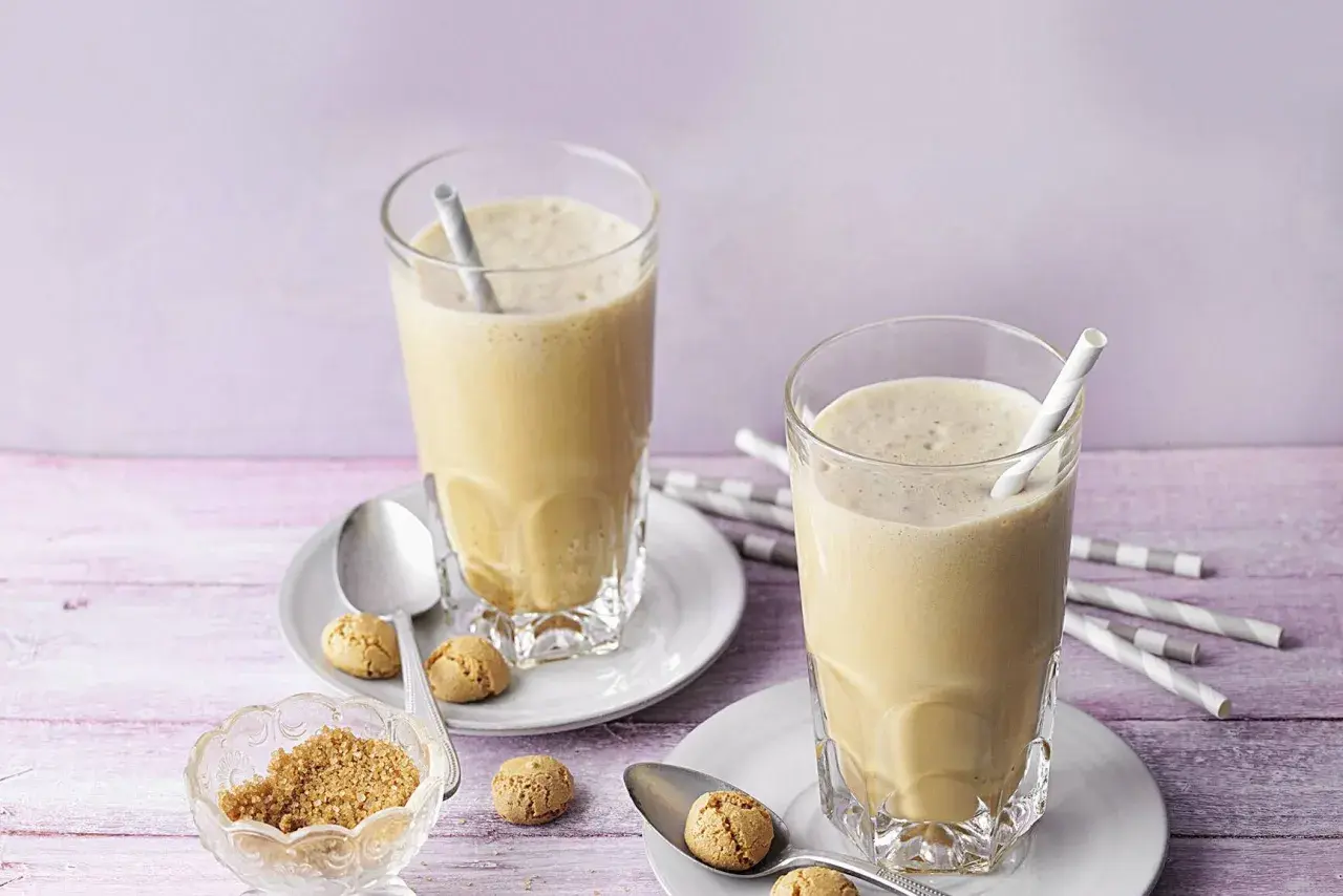 Zwei cremige Espresso Frappés mit Keksen und braunem Zucker.