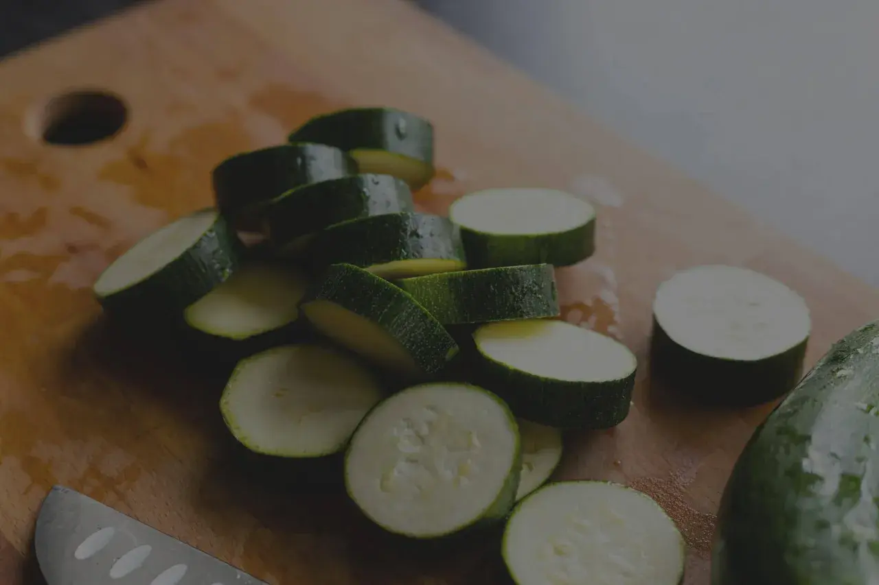 Frisch geschnittene Zucchini-Scheiben auf einem Holzbrett. Die Zucchini haltbarkeit ist gut, wenn sie richtig gelagert wird.