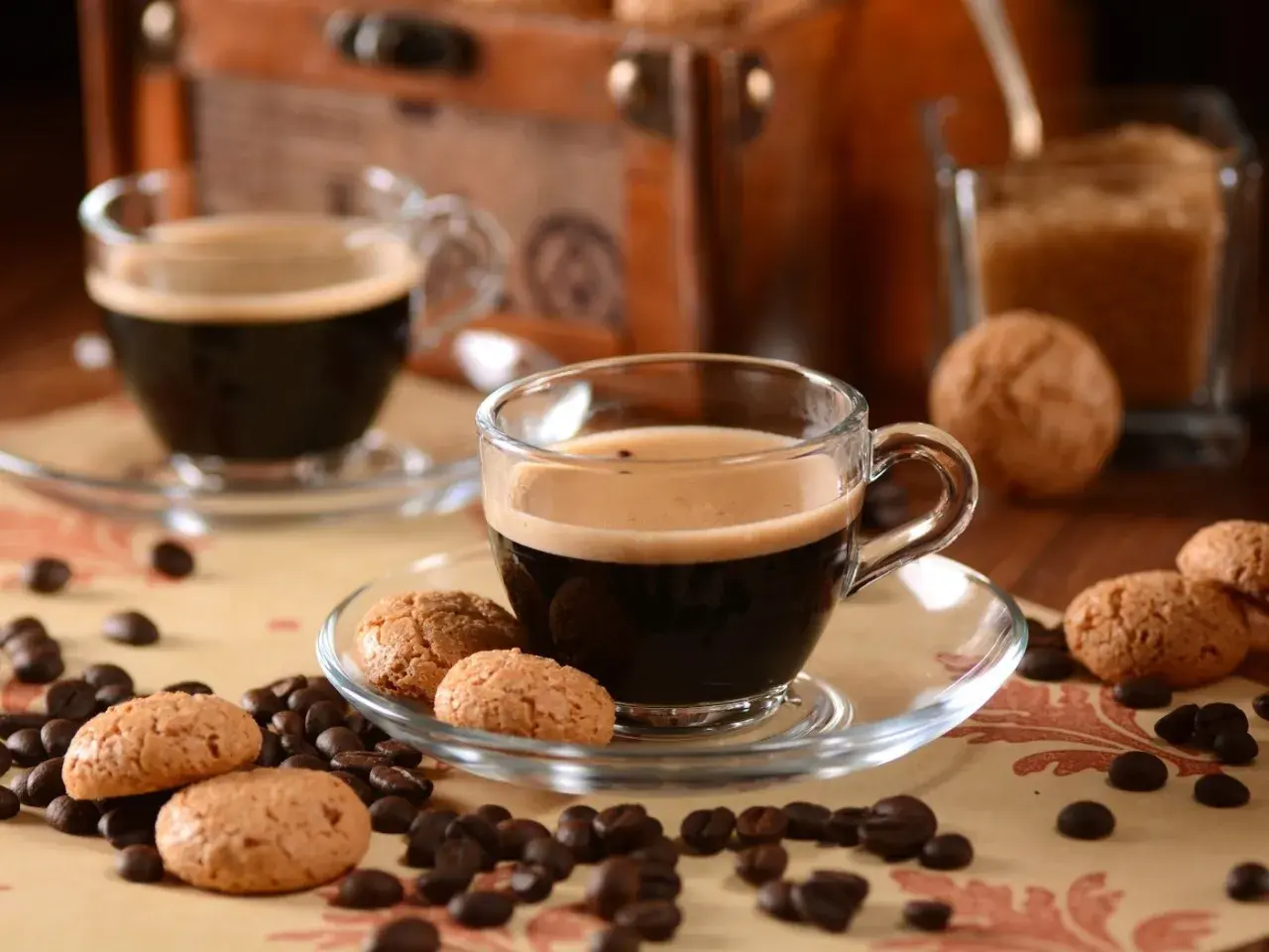 Zwei Tassen italienische Kaffeesorten mit Amarettini und Kaffeebohnen.